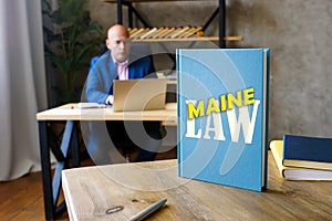 Jurist holds LAW MAINE book. Maine residents are subject to Maine state and U.S. federal laws