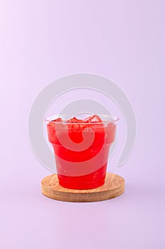 Jus semangka drink in disposable plastic take away cup. Fresh iced Smoothie made from watermelon and melon pulp. Melon and