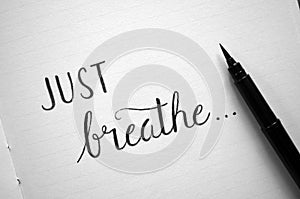 `JUST BREATHE` hand-lettered in notebook