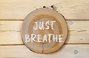 Just breathe and psychological symbol. Concept words Just breathe on beautiful wooden circle. Beautiful wooden wall background.