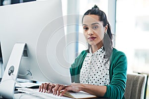 Just call me the SEO savant. Portrait of a young businesswoman using a computer in a modern office. photo