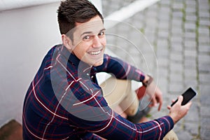 Just contacted my friends. High angle portrait of a handsome young man sitting on some steps outside.