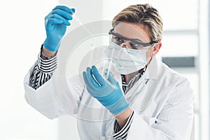 Just a few drops will do. Cropped shot of an attractive young female scientist dropping a liquid sample into a beaker
