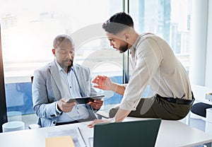 Just hear me out. two businessmen sitting in the office together and having a discussion while using a digital tablet.