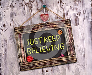 Just keep believing written on Vintage sign board
