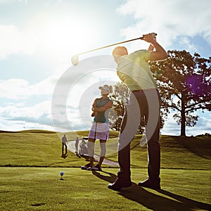 He just keeps getting better anf better. a couple playing golf together on a fairway.