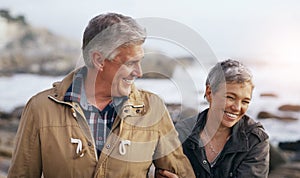 Just like the good old days. a beautiful elderly couple taking a walk at the beach.