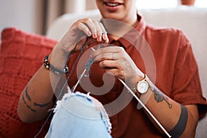 Just like my granny taught me. a young woman knitting while relaxing at home.