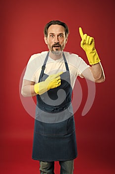 Just look over there. Mature man pointing finger up in yellow gloves. Mature household worker presenting something