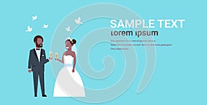 Just married african american couple standing together bride and groom holding champagne glasses wedding day concept