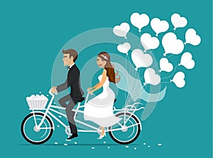 Just married couple bride and groom riding tandem bike