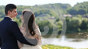 Just married couple, bride wearing wedding dress and groom with black suit, lake mirroring the beautiful mountain woods