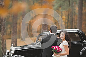 Just married couple in the luxury retro car on their wedding day