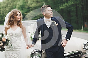 Just married couple in the luxury retro car on their wedding day