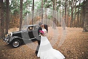 Just married couple in the luxury retro car on their wedding day