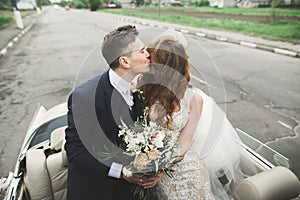 Just married couple in the luxury retro car on their wedding day