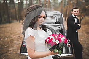 Just married couple in the luxury retro car on their wedding day