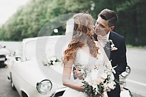 Just married couple in the luxury retro car on their wedding day