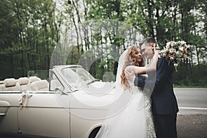 Just married couple in the luxury retro car on their wedding day