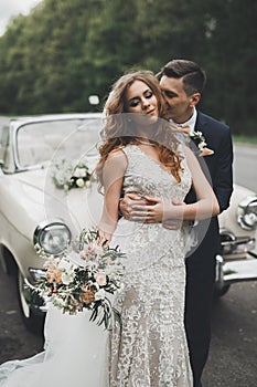 Just married couple in the luxury retro car on their wedding day