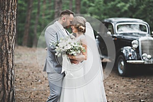 Just married couple in the luxury retro car on their wedding day