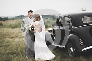 Just married couple in the luxury retro car on their wedding day