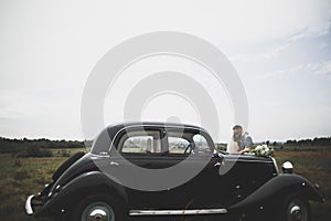 Just married couple in the luxury retro car on their wedding day