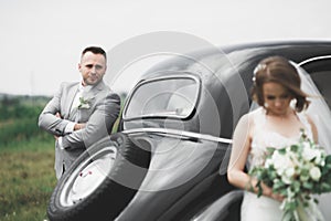 Just married couple in the luxury retro car on their wedding day