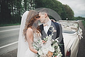 Just married couple in the luxury retro car on their wedding day