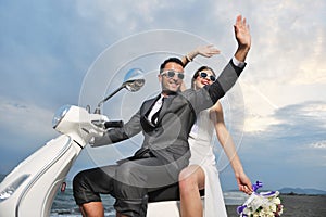 Just married couple ride white scooter