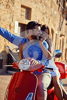 Just married couple riding motor scooter in city street