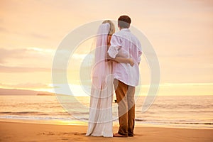Just married couple on tropical beach at sunset