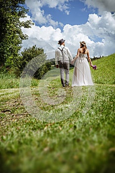 Just married couple walking through the park