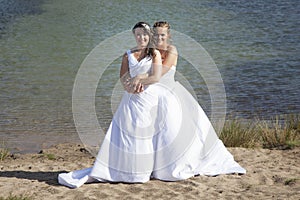 Just married happy lesbian couple in white dress embrace near sm