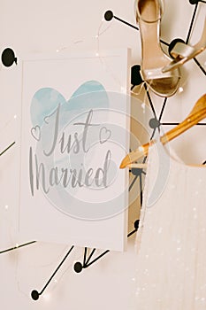Just married sign with wedding dress and shoes on white wall background