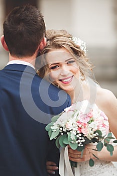 Just married wedding couple posing and bride holding in hands bouquet