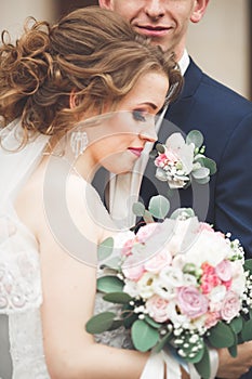 Just married wedding couple posing and bride holding in hands bouquet