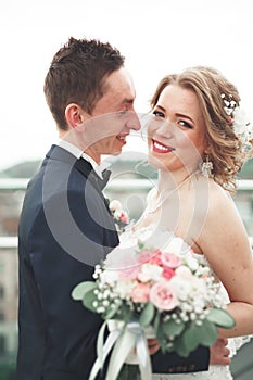 Just married wedding couple posing and bride holding in hands bouquet