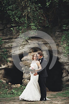 Just married wedding couple posing and bride holding in hands bouquet