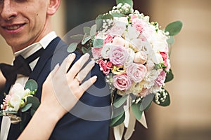 Just married wedding couple posing and bride holding in hands bouquet