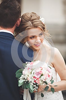 Just married wedding couple posing and bride holding in hands bouquet