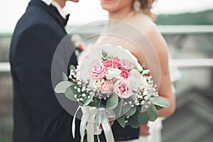 Just married wedding couple posing and bride holding in hands bouquet