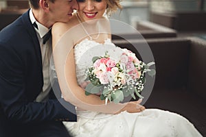 Just married wedding couple posing and bride holding in hands bouquet