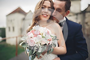 Just married wedding couple posing and bride holding in hands bouquet