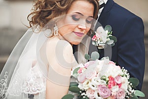 Just married wedding couple posing and bride holding in hands bouquet