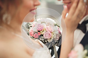 Just married wedding couple posing and bride holding in hands bouquet