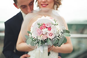 Just married wedding couple posing and bride holding in hands bouquet