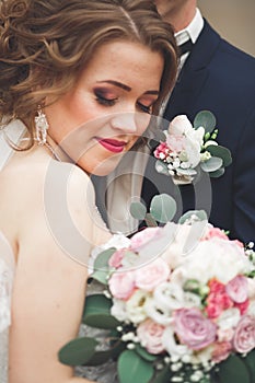 Just married wedding couple posing and bride holding in hands bouquet