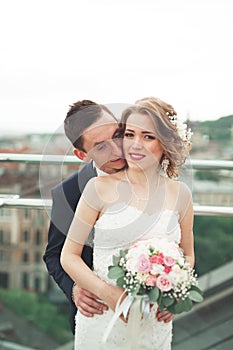 Just married wedding couple posing and bride holding in hands bouquet