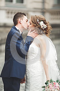 Just married wedding couple posing and bride holding in hands bouquet